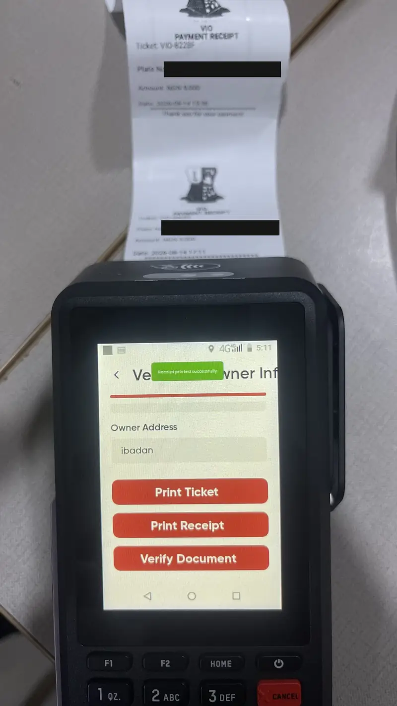 OYO-VIO on a POS terminal showing "Receipt printed successfully", with two VIO payment receipts fed out of the printer. Plate numbers redacted.